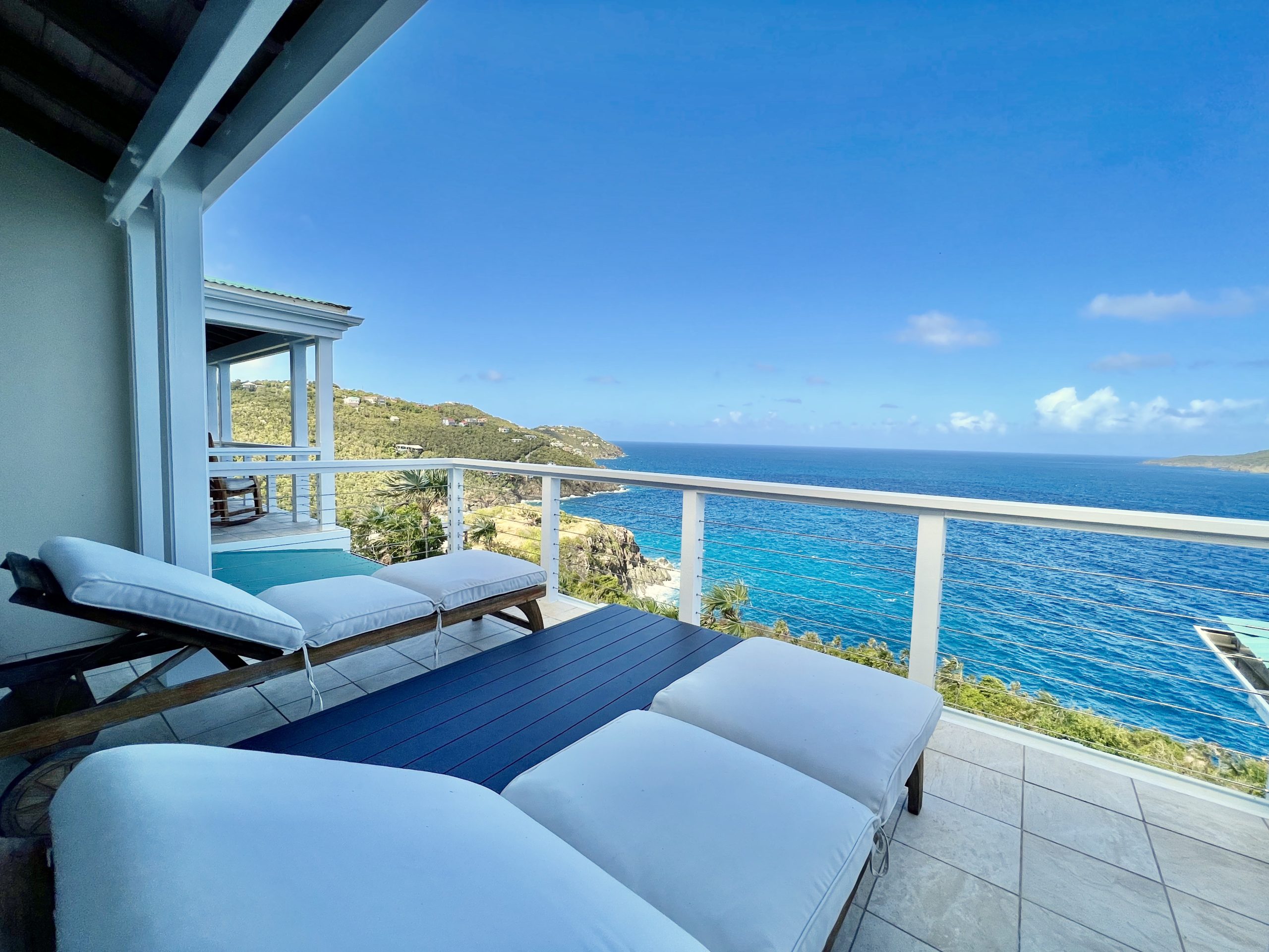 white cushioned deck chairs overlooking Caribbean ocean